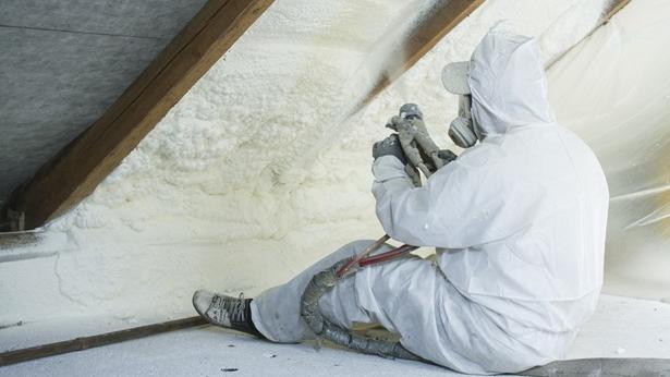 Man spraying insulation in attic